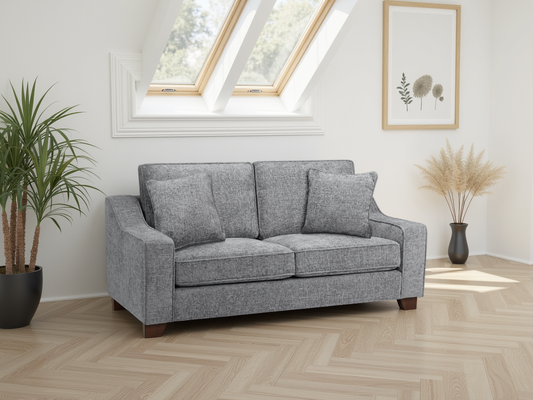 Gray sofa in a room with a skylight and decorative plants.