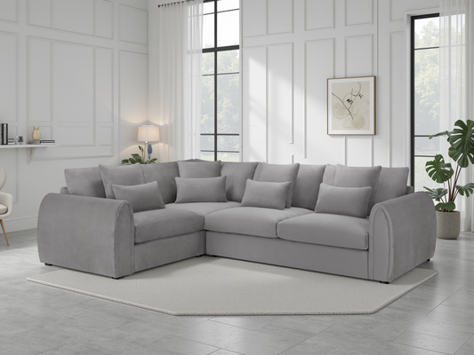 Gray sectional sofa in a modern living room with large windows and decorative elements.