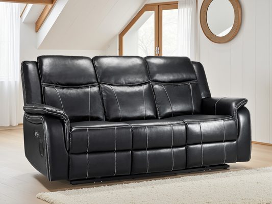 Black leather sofa in a living room setting with wooden floor and white walls.