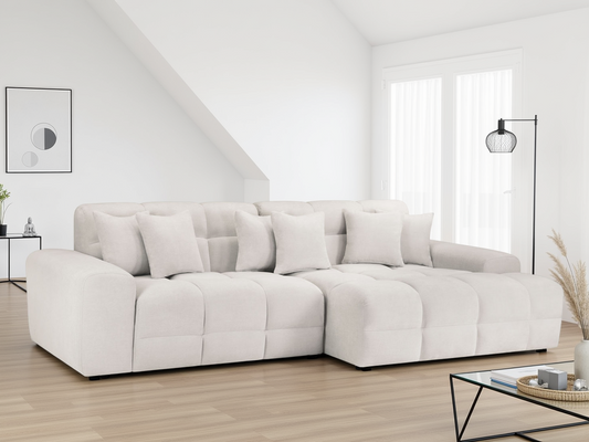 White sectional sofa in a modern living room with wooden floor and large windows.