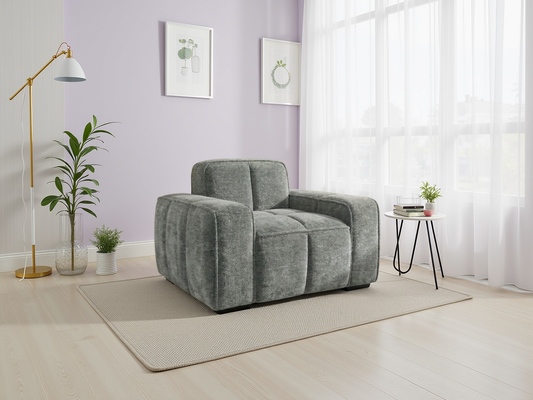 Gray armchair in a modern living room with a purple wall, floor lamp, and small table.