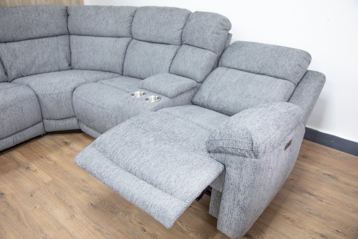 Gray sectional sofa with reclining feature on a wooden floor.