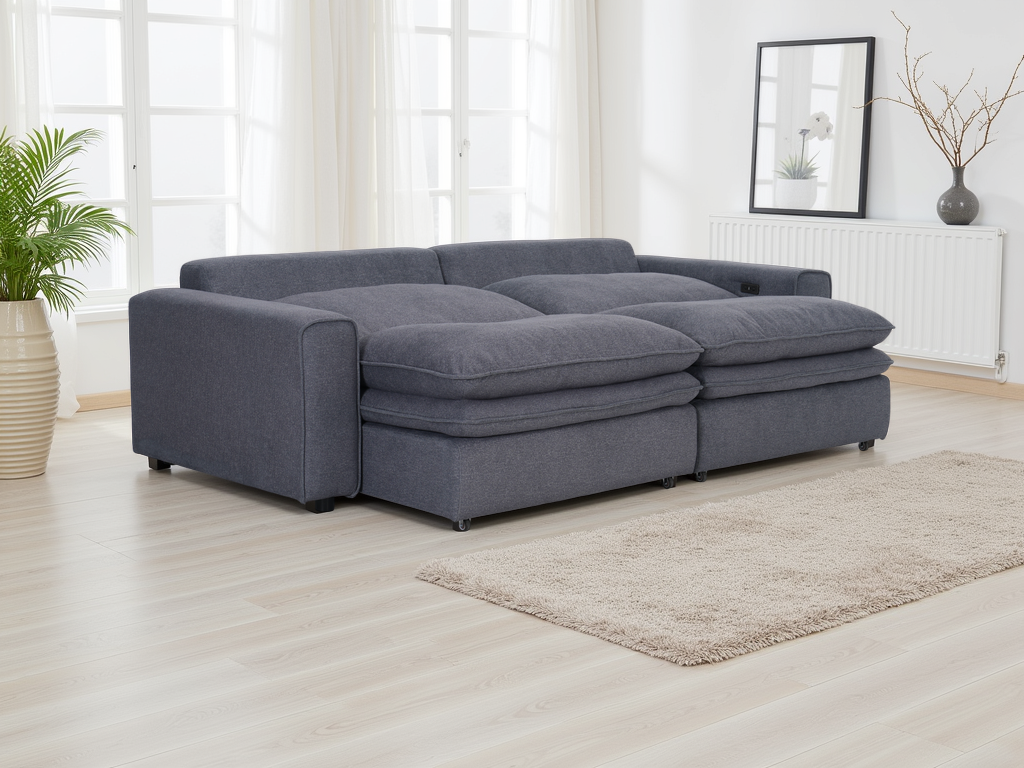Gray sectional sofa in a room with large windows and a plant.