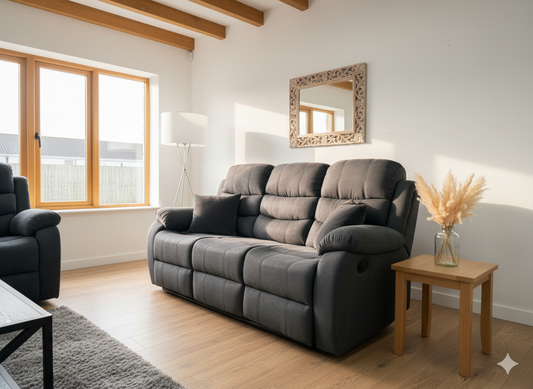Black sofa in a living room with wooden floor and large windows.