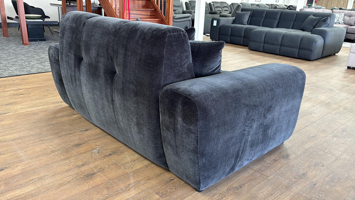 black sofa in a showroom setting with other furniture.