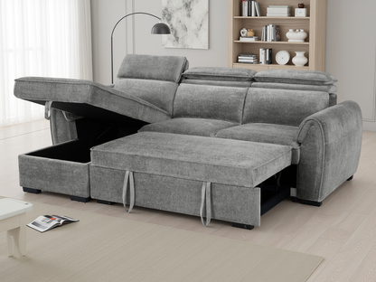 A gray upholstered sectional sofa with a chaise lounge and raised storage ottoman section, shown in a bright modern living room.