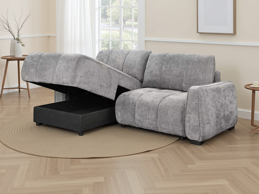 A light grey textured fabric sectional sofa with a chaise lounge on one end.