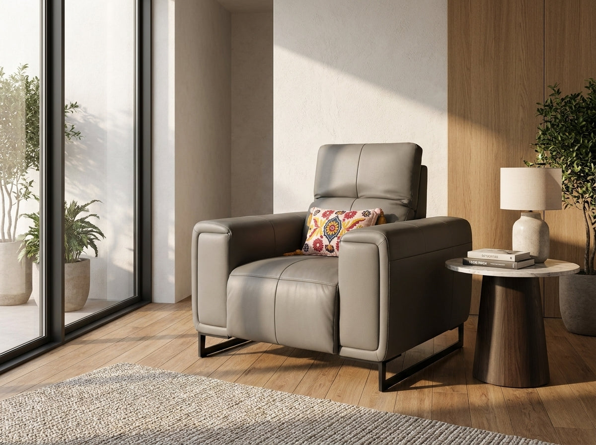 A modern gray leather recliner chair with black metal legs, styled in a bright living room.