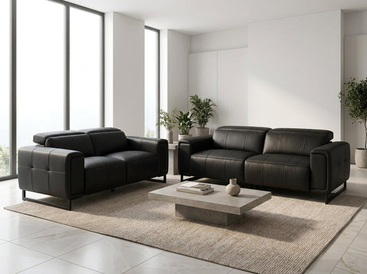 A modern living room setup featuring a black leather loveseat and a matching black leather three-seater sofa.