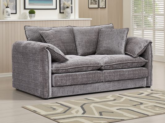 Gray sofa in a living room setting with a patterned rug and decor.