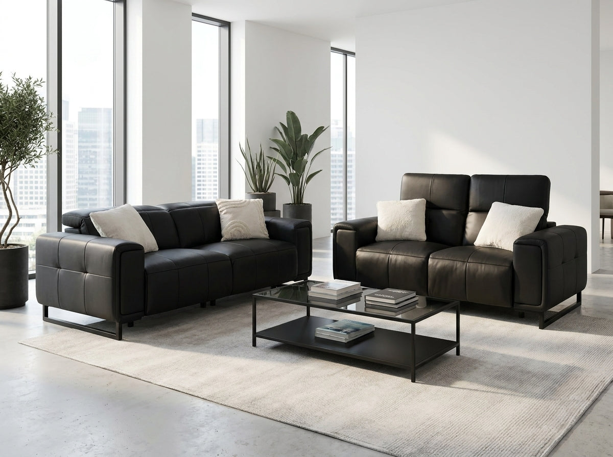 A modern living room setup featuring a black leather loveseat and a matching black leather sofa.