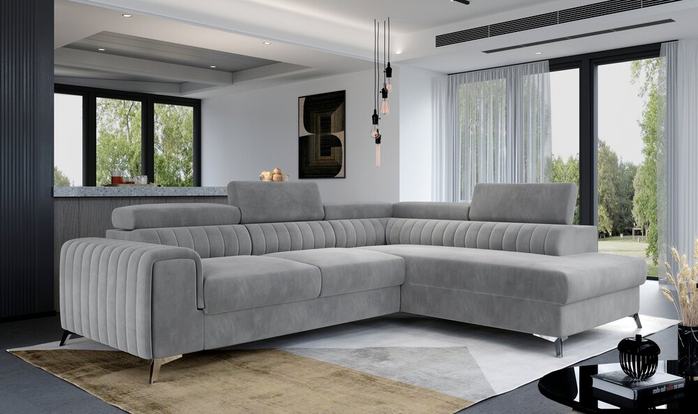 A modern light gray tufted sectional sofa with a chaise lounge, shown in a contemporary living room.