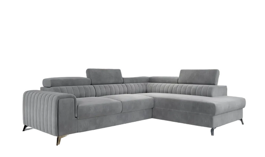 A modern light grey tufted sectional sofa with a chaise lounge, shown in a contemporary living room.