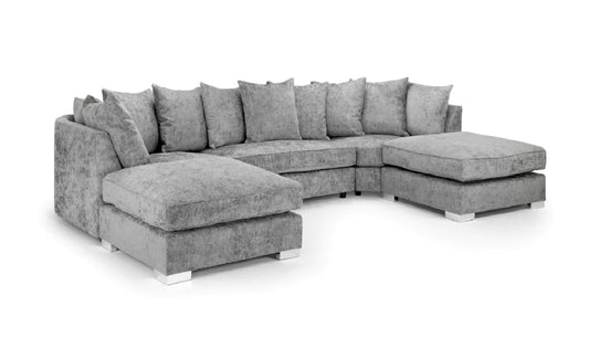 A gray upholstered sectional sofa with multiple matching throw pillows, a chaise ottoman on the left, and a right-facing chaise ottoman, shown on a plain white background.