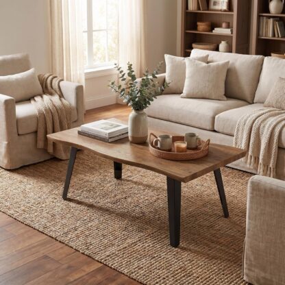 A rectangular wooden coffee table with black angled legs in a bright, neutral living room. 