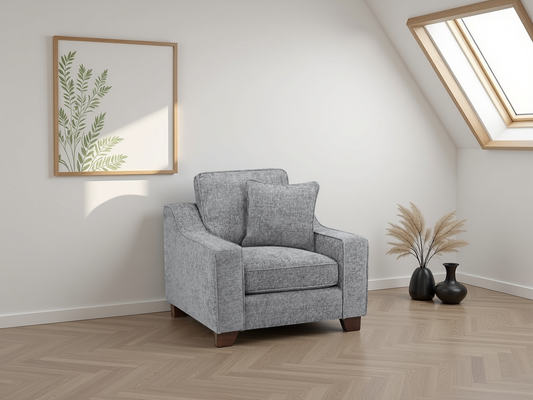 Gray armchair in a room with a framed picture and decorative vases.