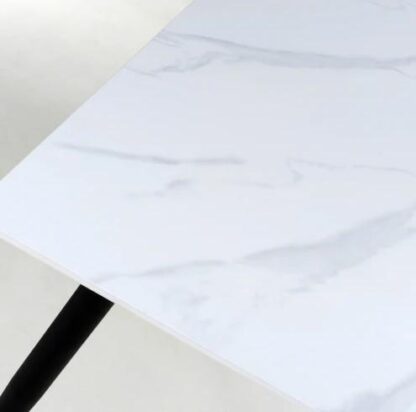 White rectangular tabletop with a light gray marble-look veining pattern and a black leg visible at the lower left, photographed on a clean white background.
