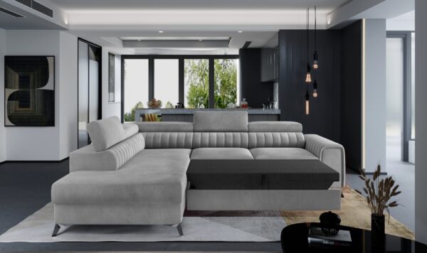 A modern sectional sofa in light grey and dark grey, styled in a contemporary living room with a black kitchen in the background.