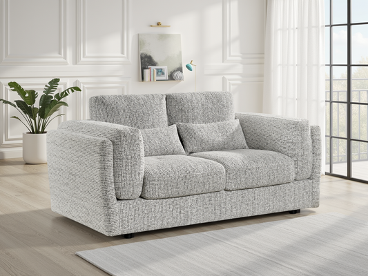 Gray sofa in a living room with a plant and window in the background