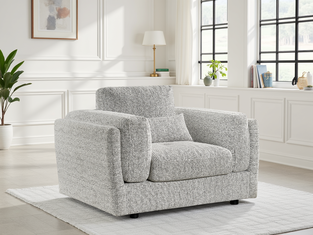 Gray armchair in a bright living room with white walls and large windows.