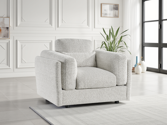 Beige armchair in a bright room with white walls and a plant.