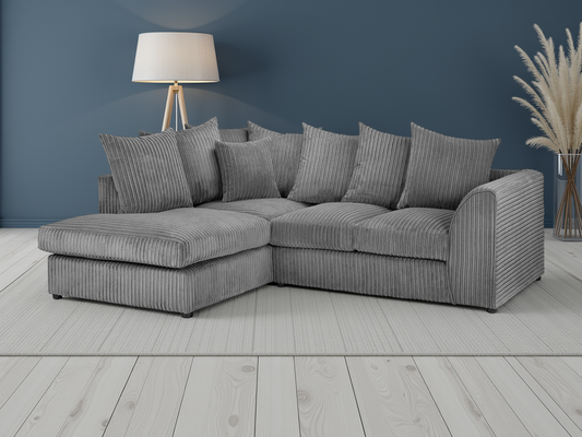 Gray sectional sofa in a room with a lamp and decorative plant.