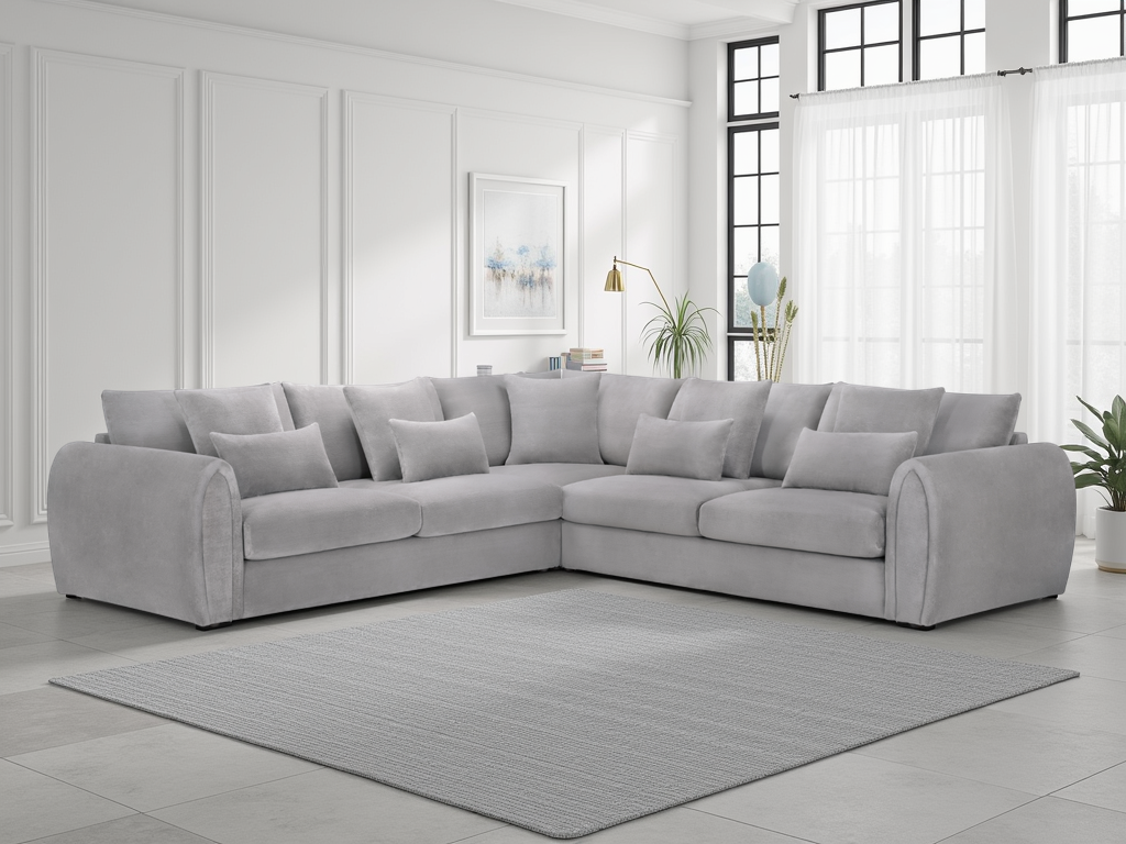 Gray sectional sofa in a living room with white walls and large windows.