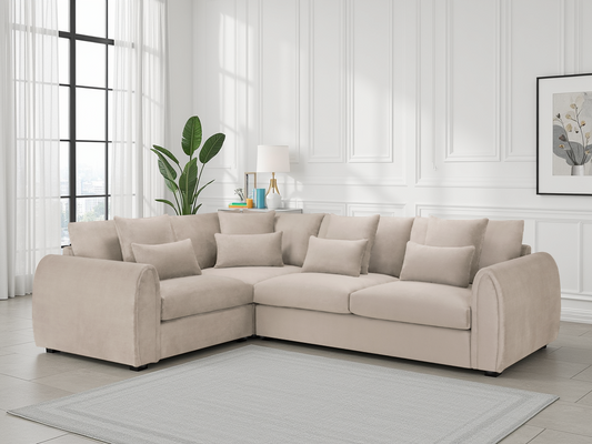 Beige sectional sofa in a living room with white walls and a plant.