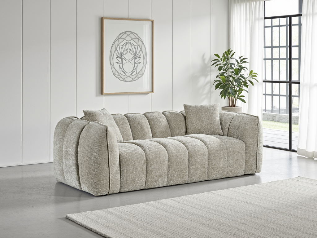 Gray sofa in a living room with a plant and framed artwork on the wall.