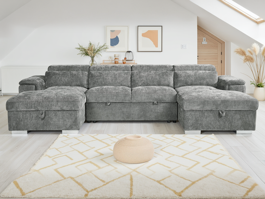 Gray sectional sofa in a living room setting with a rug and decor.