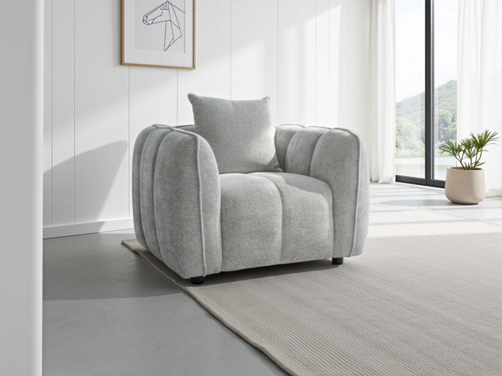 Gray armchair in a modern living room with a white wall and large window.