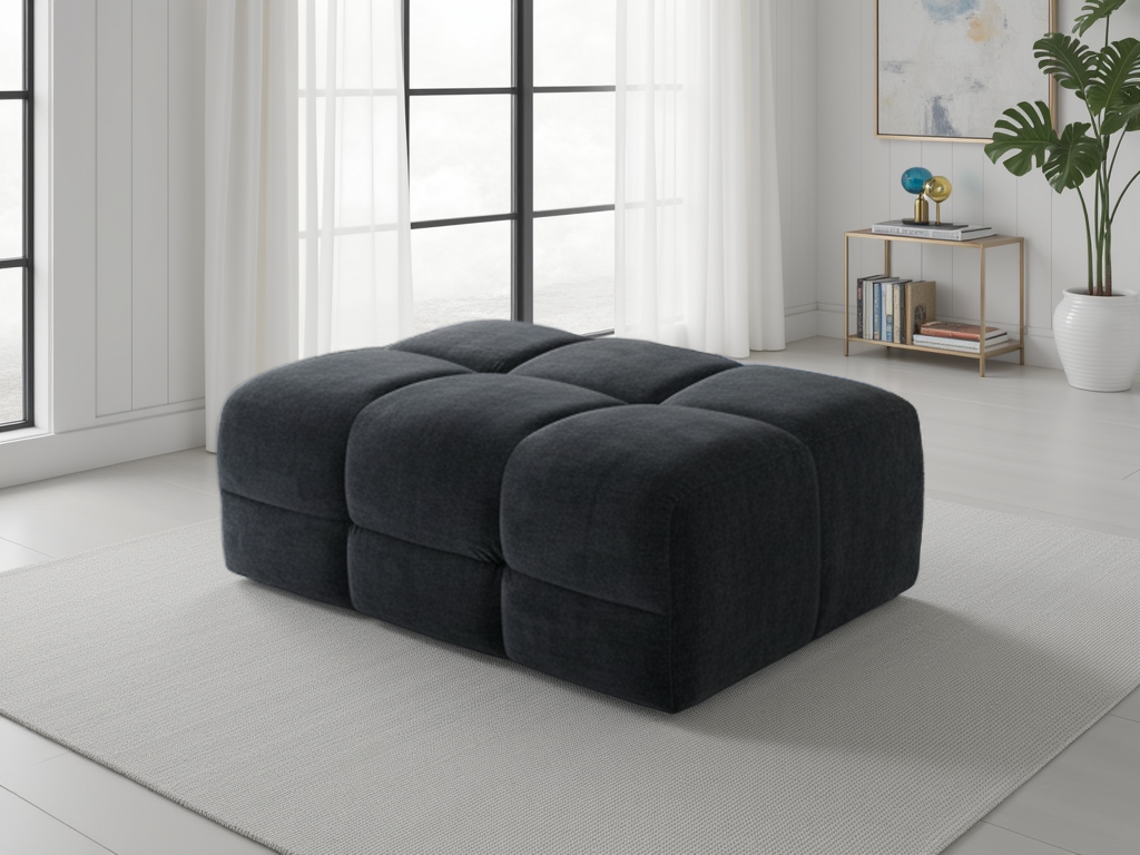 Dark black ottoman in a modern living room with large windows and minimal decor.
