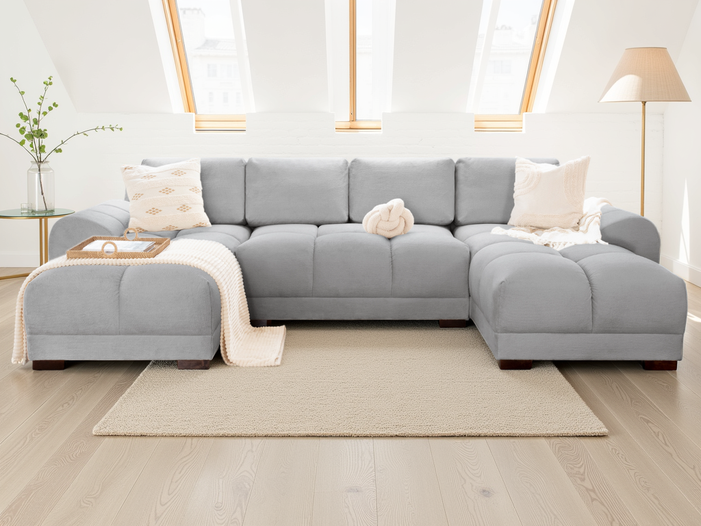 Gray sectional sofa in a bright living room with large windows.
