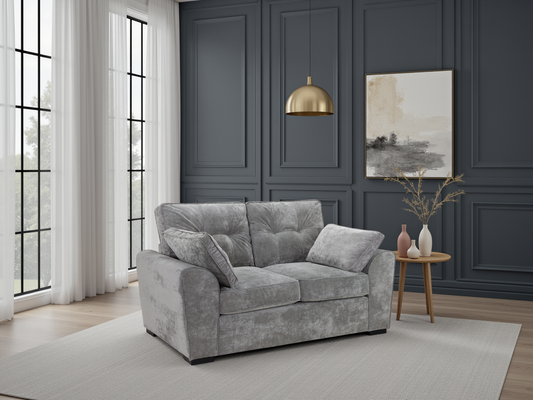 Gray sofa in a living room with dark paneled walls, a gold pendant light, and a small table with decorative items.
