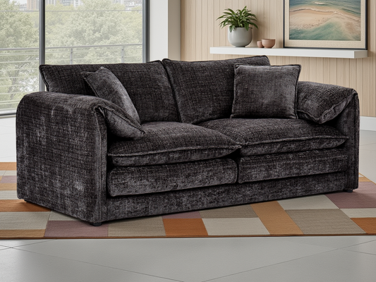 Black sofa in a living room with a colorful rug and window in the background