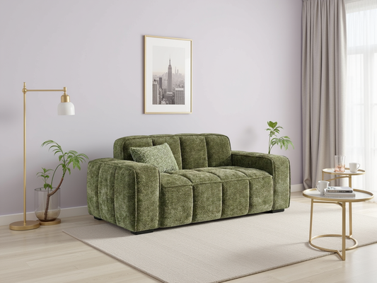 Green sofa in a living room with a lamp, table, and plants.