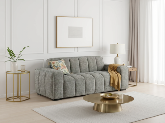 Gray sofa in a living room with gold coffee table and side table, white walls and curtains.