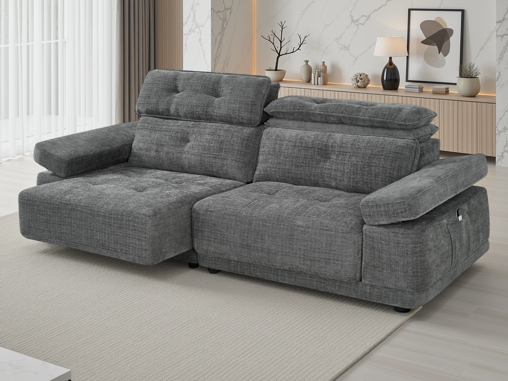 A modern gray fabric reclining sofa with a chaise lounge, shown in a styled living room setting with a light-colored rug, wooden console, and wall decor.