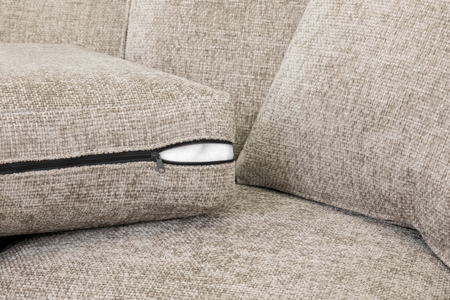 Close-up of a beige fabric sofa with a visible seam.