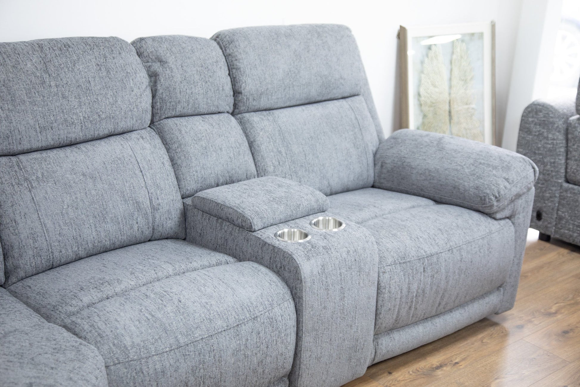 Gray sofa with cup holders on a wooden floor