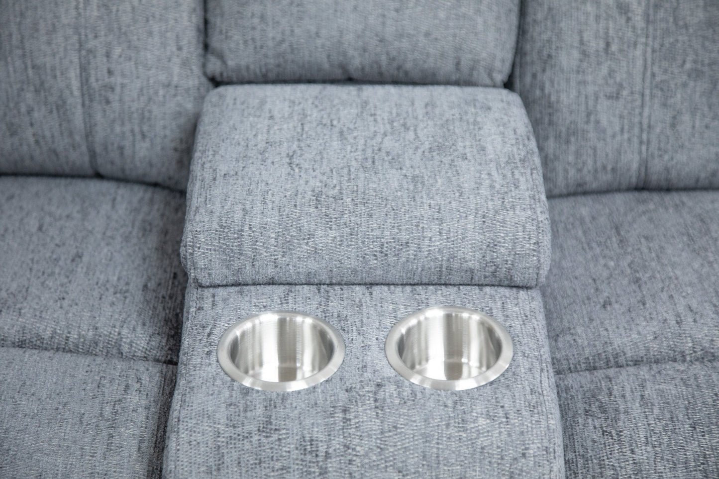 Two metallic cup holders embedded in a gray upholstered surface.