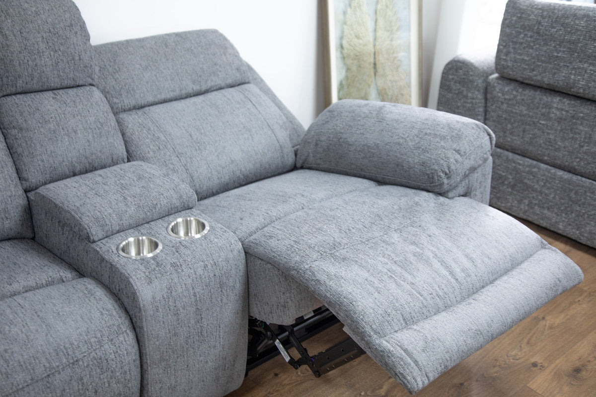 Gray recliner sofa with cup holders on a wooden floor.