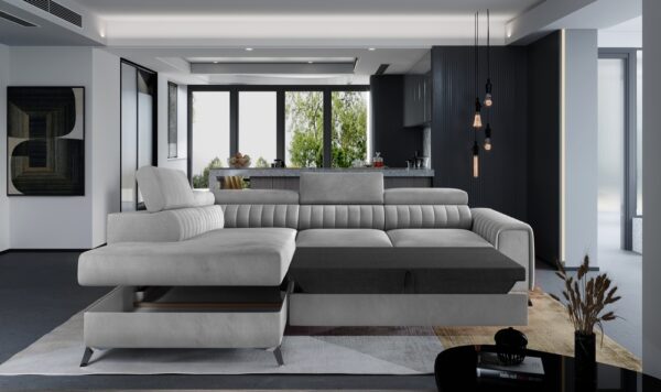 A modern sectional sofa in light grey and dark grey, styled in a contemporary living room with a black kitchen in the background.