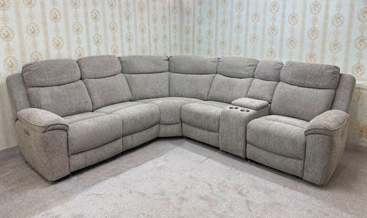 A light gray upholstered sectional sofa with recliner cushions and a center console, shown in a room with patterned wallpaper and a light rug.