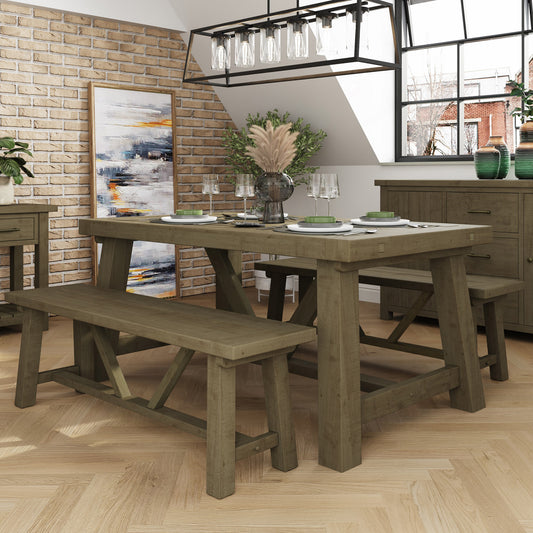 Dining room with wooden table and benches against a brick wall.