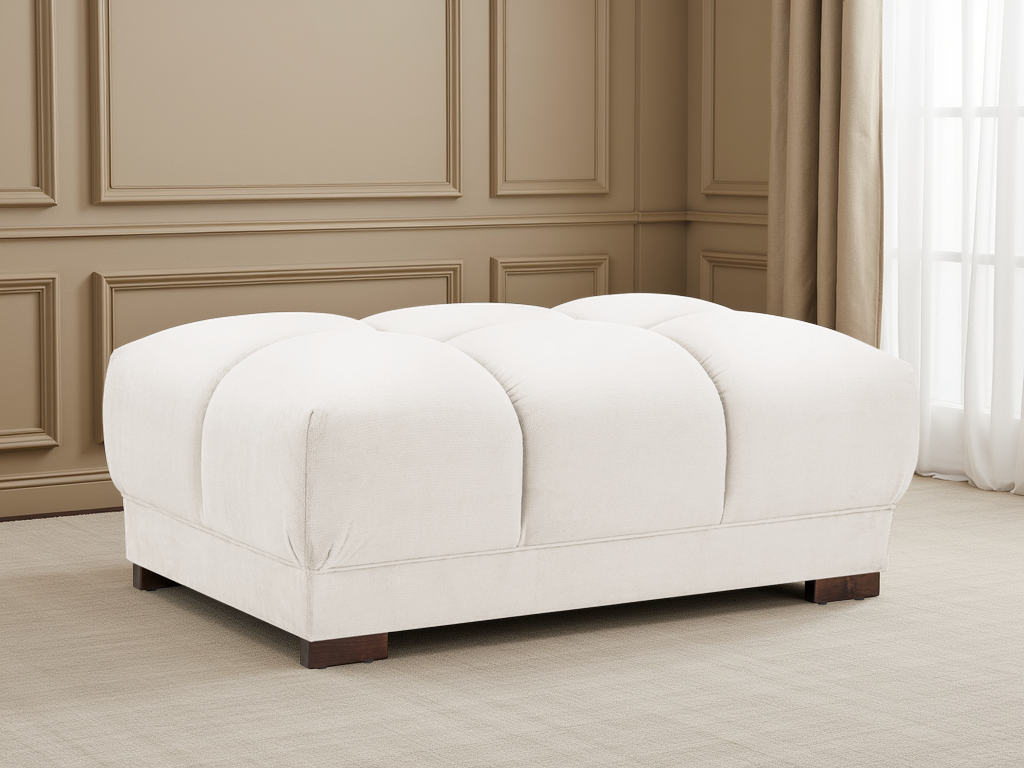 White ottoman in a room with beige walls and white curtains