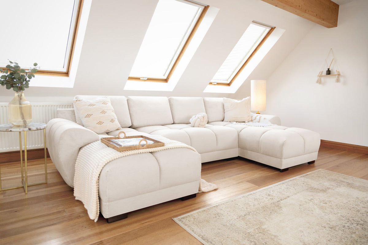 Modern living room with a white sectional sofa, wooden coffee table, and skylights.