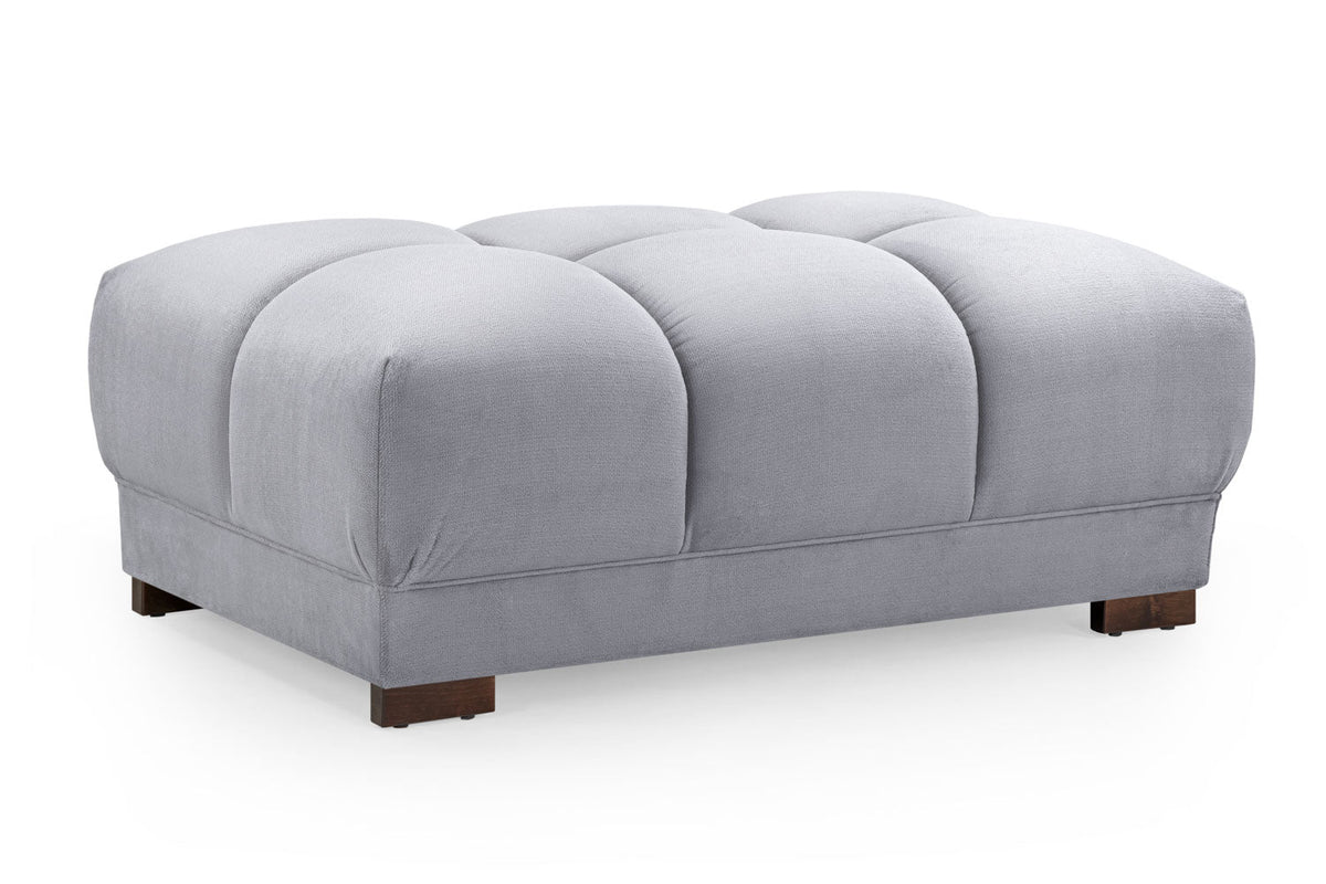 Gray tufted ottoman on a white background