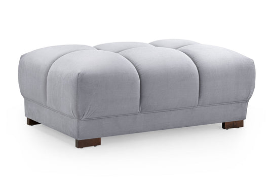 Gray tufted ottoman on a white background