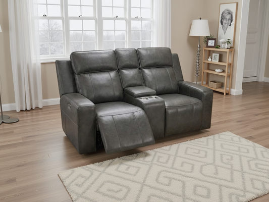 Gray leather recliner sofa in a living room setting with a rug and window.